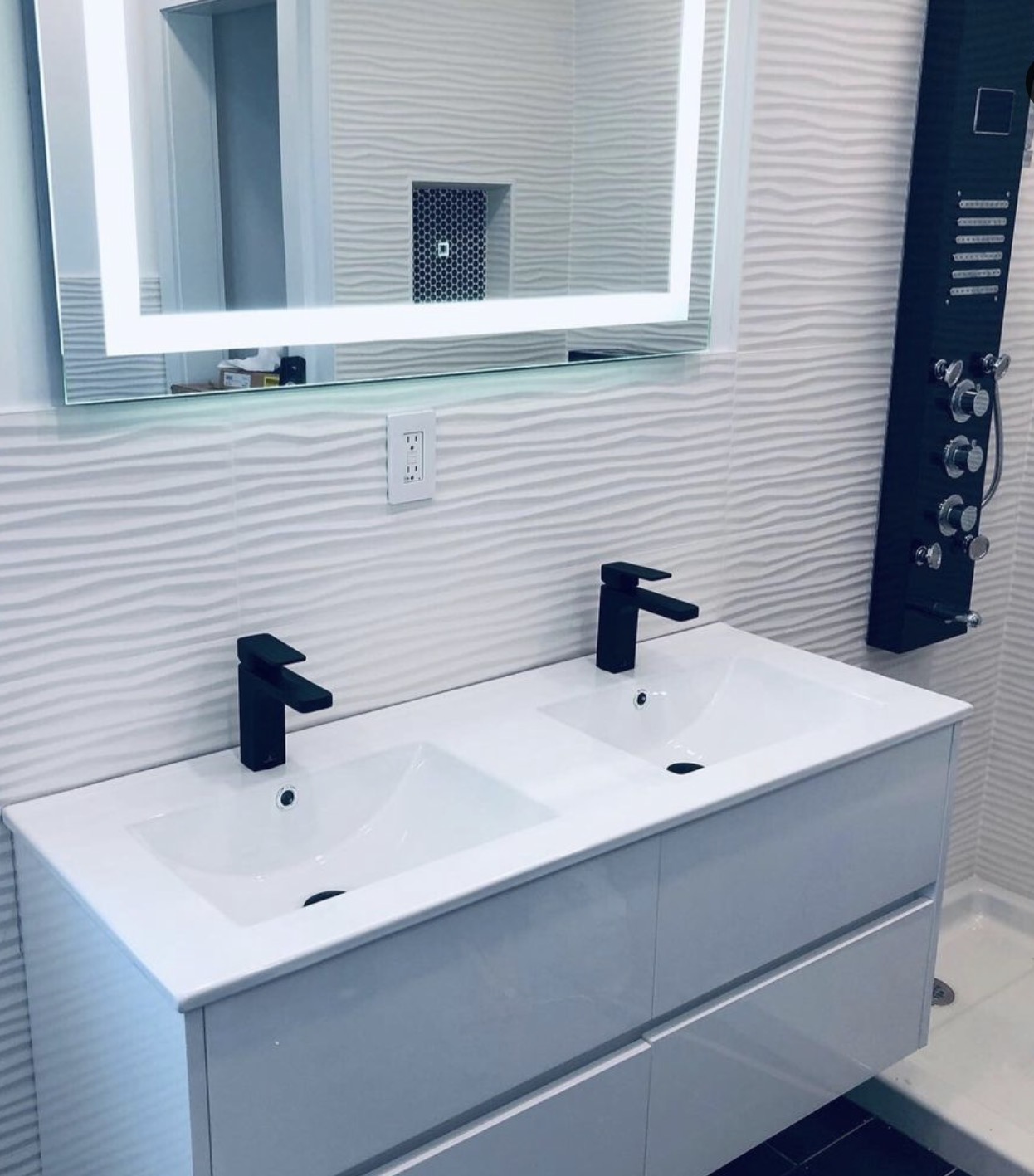 Bathroom double vanity with textured tile wall and multi-function shower panel