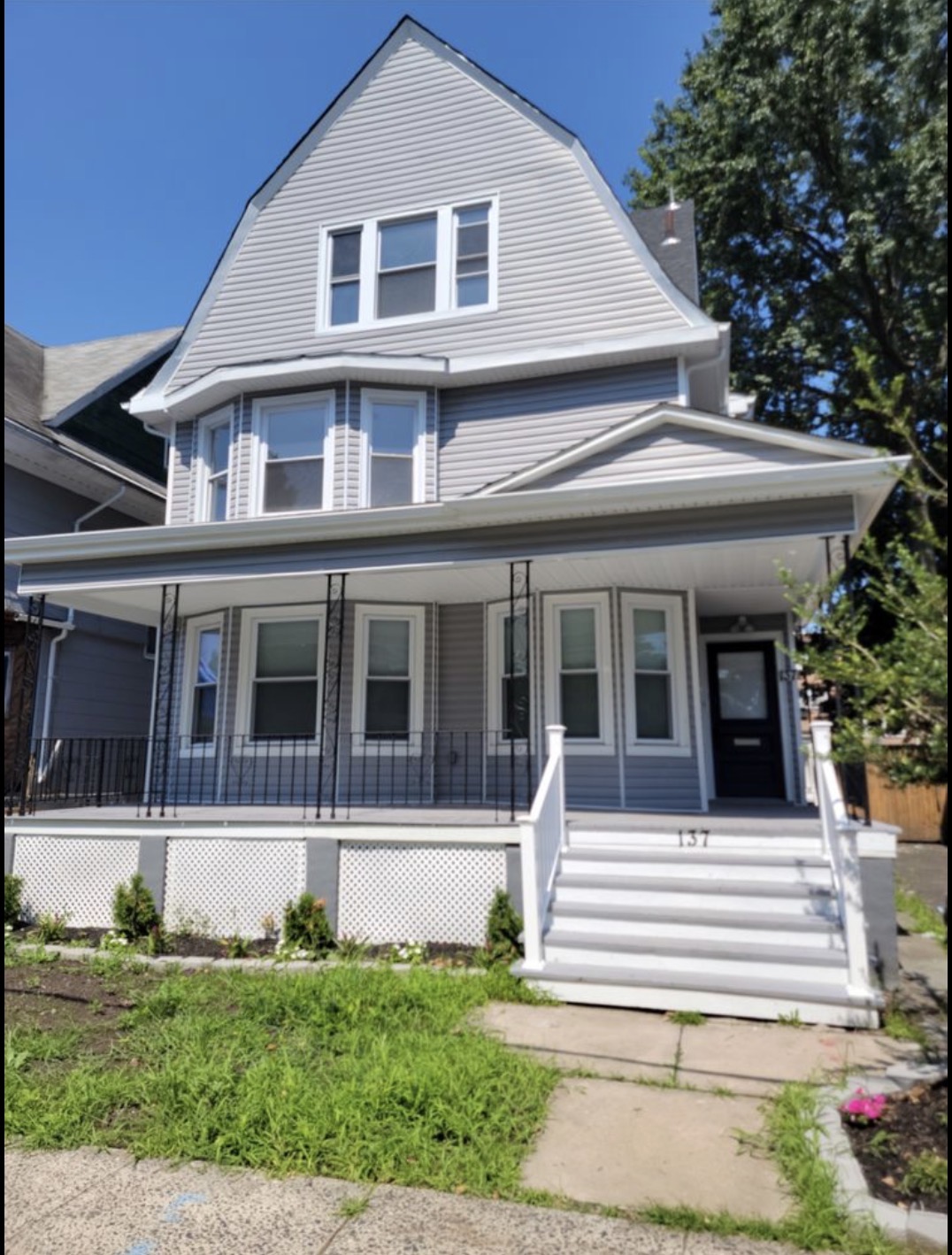 Renovated Victorian-style home exterior with wraparound porch
