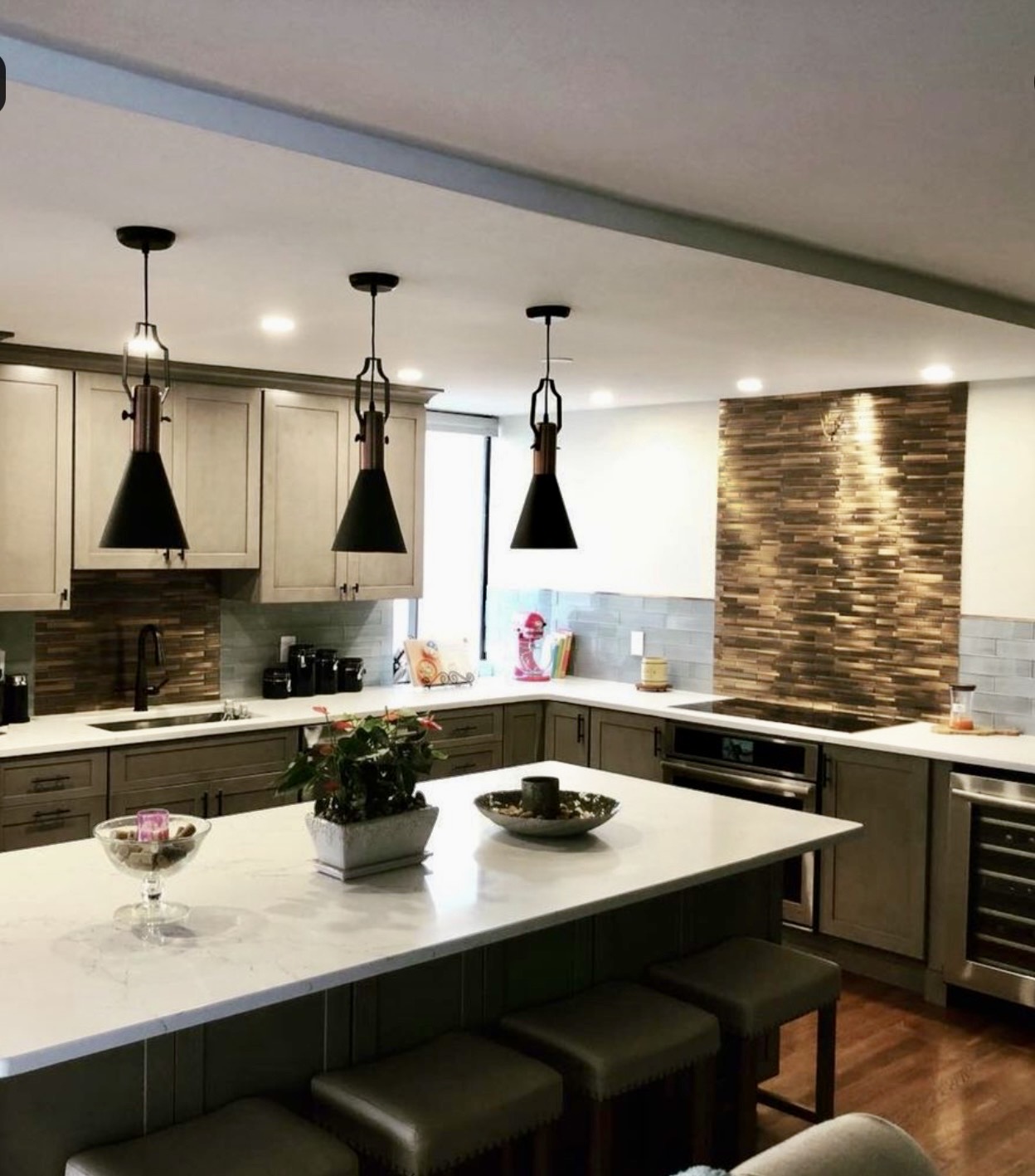 Kitchen renovation with wood accent wall and black pendant lighting