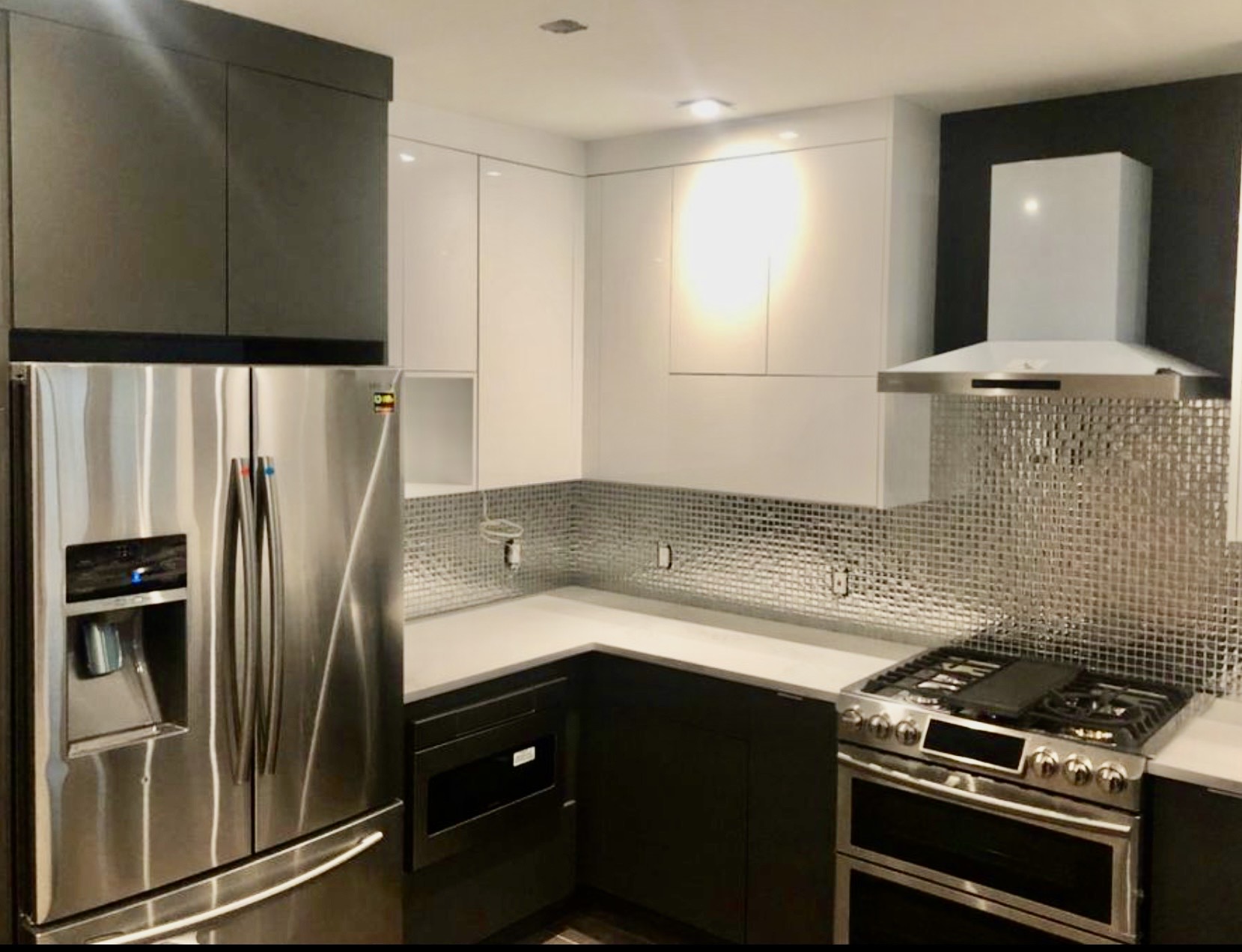 Kitchen with stainless steel appliances and mosaic tile backsplash